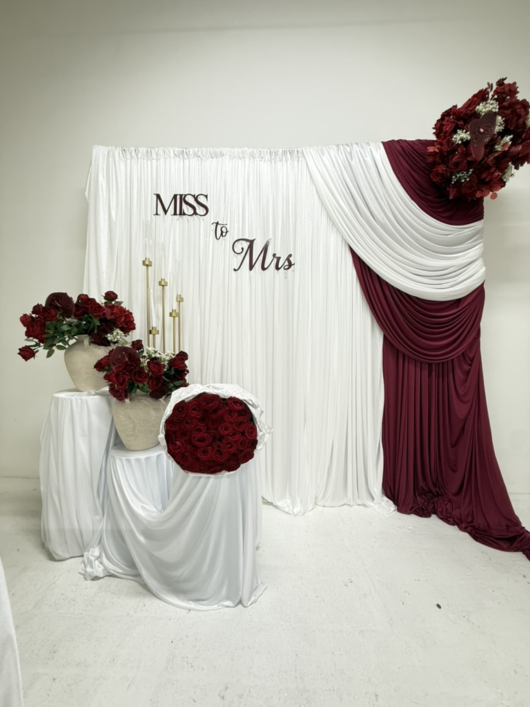 Burgundy and white Miss to Mrs bridal shower draping with red florals and gold table styling by Nour Occasions