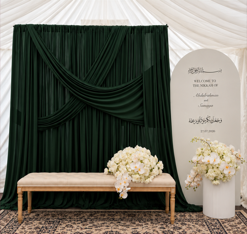 Emerald draping with an arch backdrop, bench, cake stand and two floral centrepieces